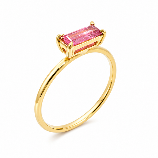 A yellow gold ring featuring a rectangular baguette-cut pink gemstone in a prong setting, shown on a clean white background.