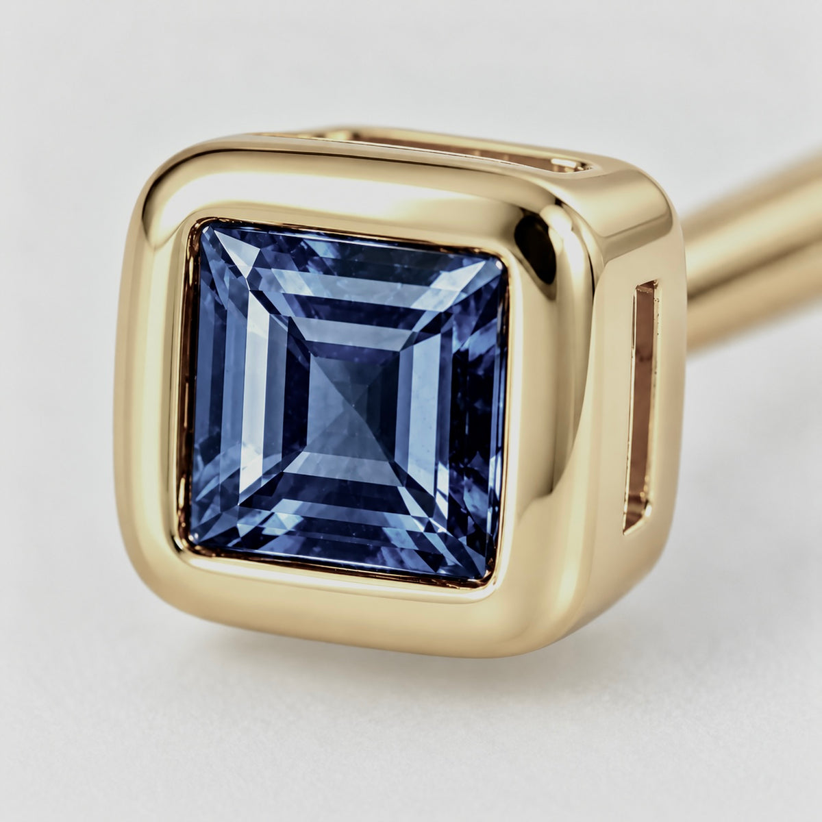 Close-up of blue sapphire bezel setting on Blue Whisper Earrings by Bed of Stones Jewelry